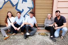 Fünf Familienmitglieder der Familie Schwarz Caroll sitzen neben den Stolpersteinen