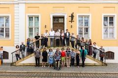 Auf und vor der Treppe des Stadtmuseums stehen die ehren- und hauptamtlichen Ausstellungsmacher*innen, 28 Personen