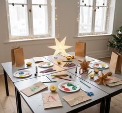 Vier Tische mit Bastelutensilien zum Sterne basteln und mit Kartoffeln stempeln