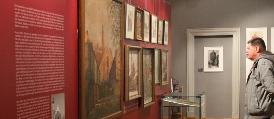 Ein Mann betrachtet Bilder in einer Kunstausstellung