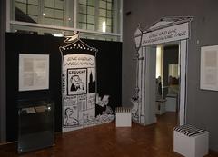Eine mit Loriot-Motiven gestaltete Litfass-Säule und ein Portal im 1. Raum der Ausstellung führen optisch zum Thema hin.