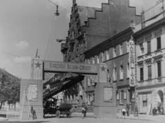 Die Überblendung reicht von dem historischen Foto von 1945 bis 2021. Auf dem Foto vom Mai 1945 steht vor dem Gebäude ein Triumphbogen aus Holz.