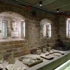 Im Keller ist eine Ausstellung zur Hausgeschichte untergebracht: in den Wandnischen sind die Objekte ausgestellt.